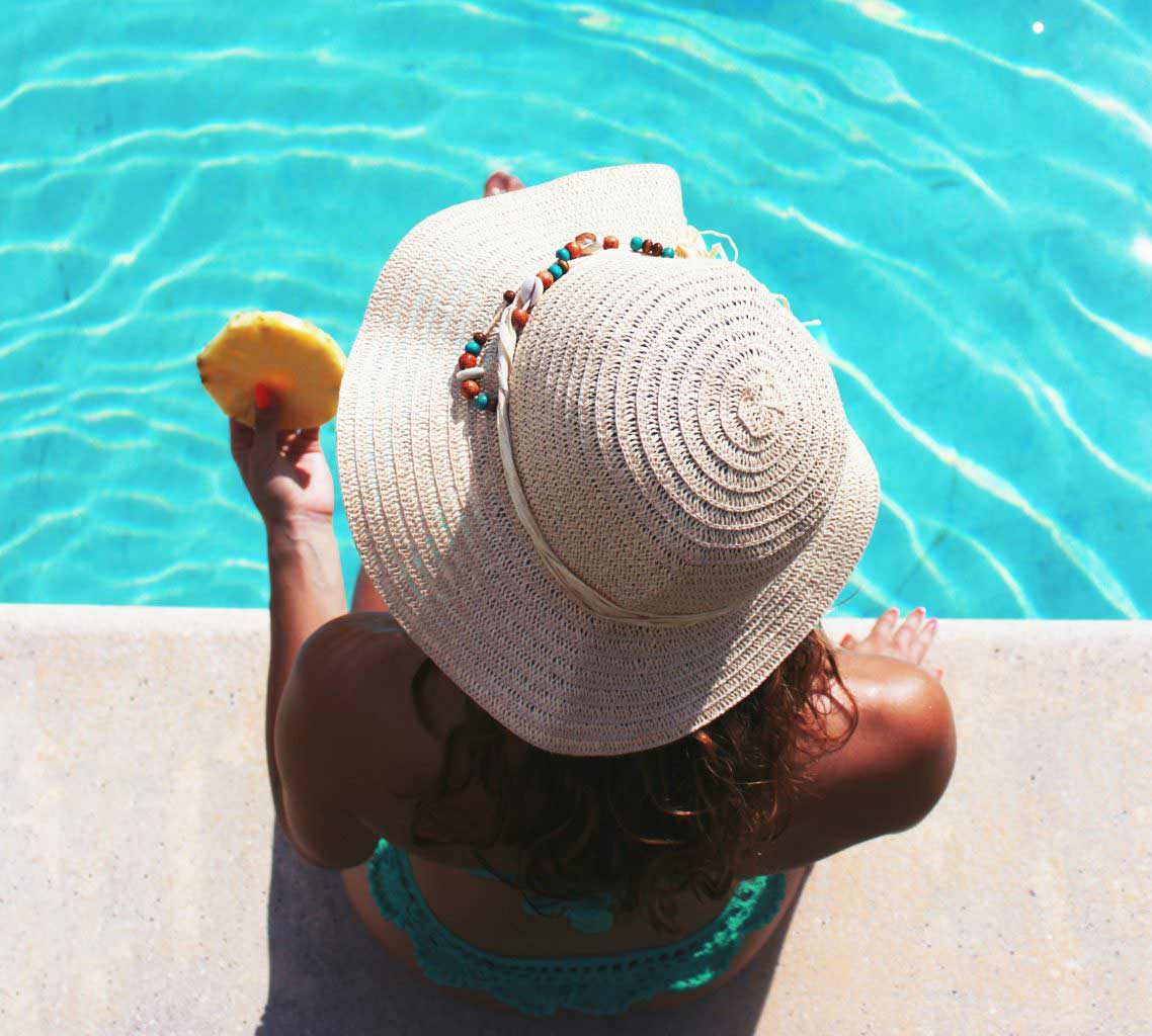 Mulher sentada na beira da piscina do Hotel Del Rey Foz