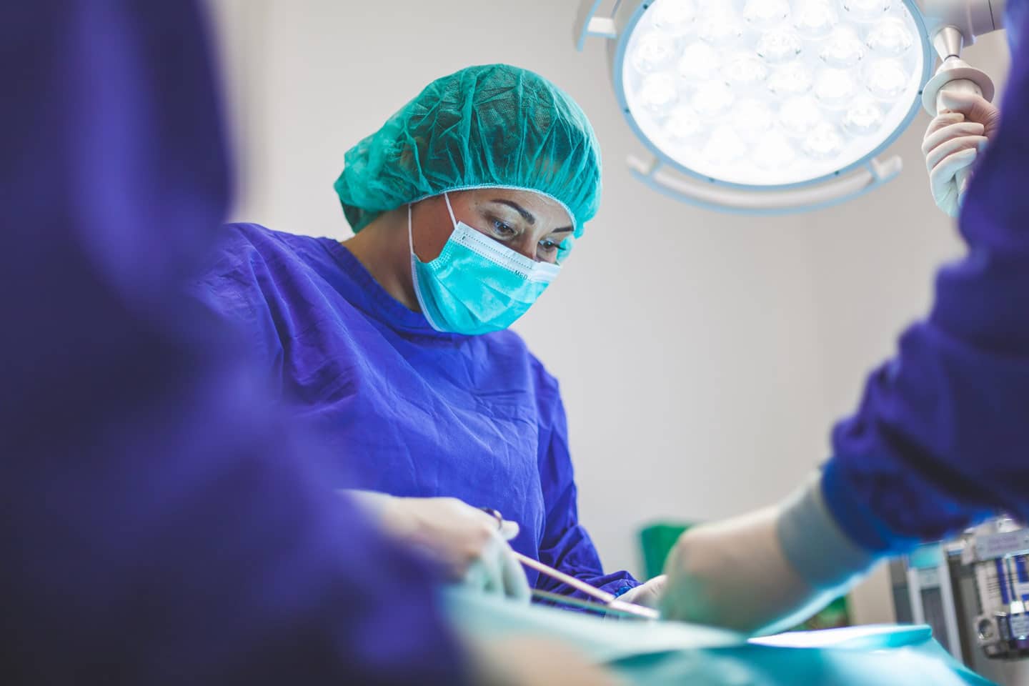 Médica operando em sala de cirurgia