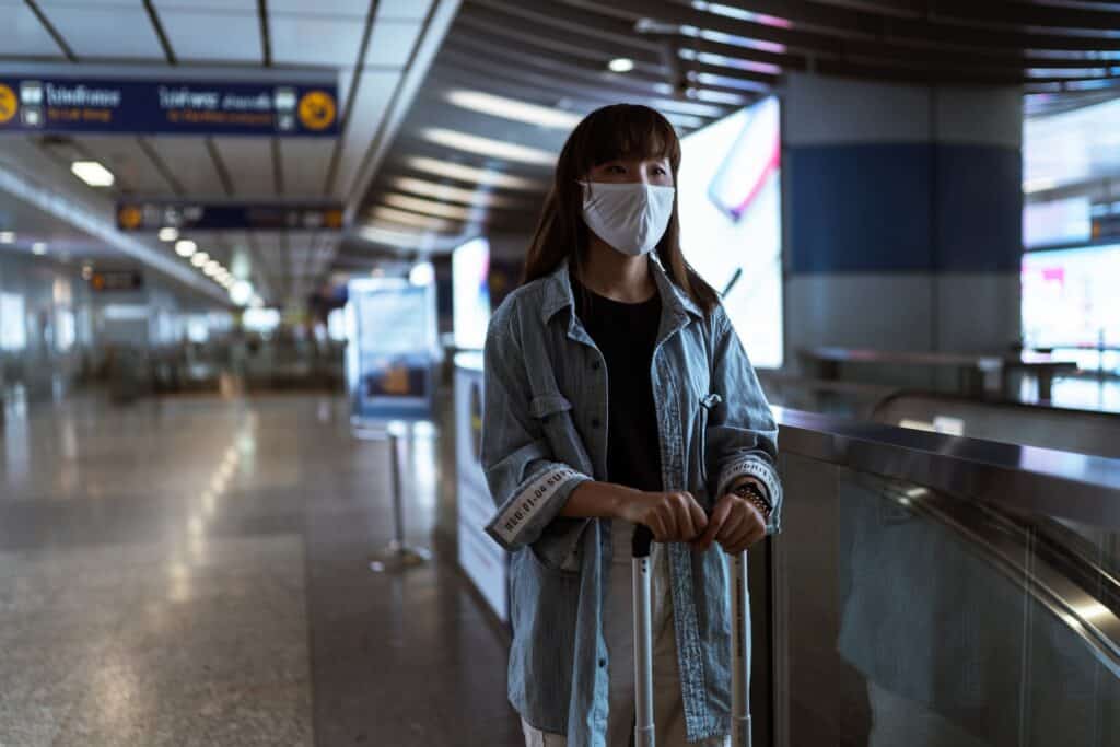 Mulher usando máscara em aeroporto