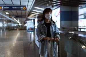 Mulher usando máscara em aeroporto